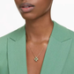 Swarovski Idyllia Pendant - Clover, GreenWoman wearing a green blazer and a delicate necklace with a green pendant.
