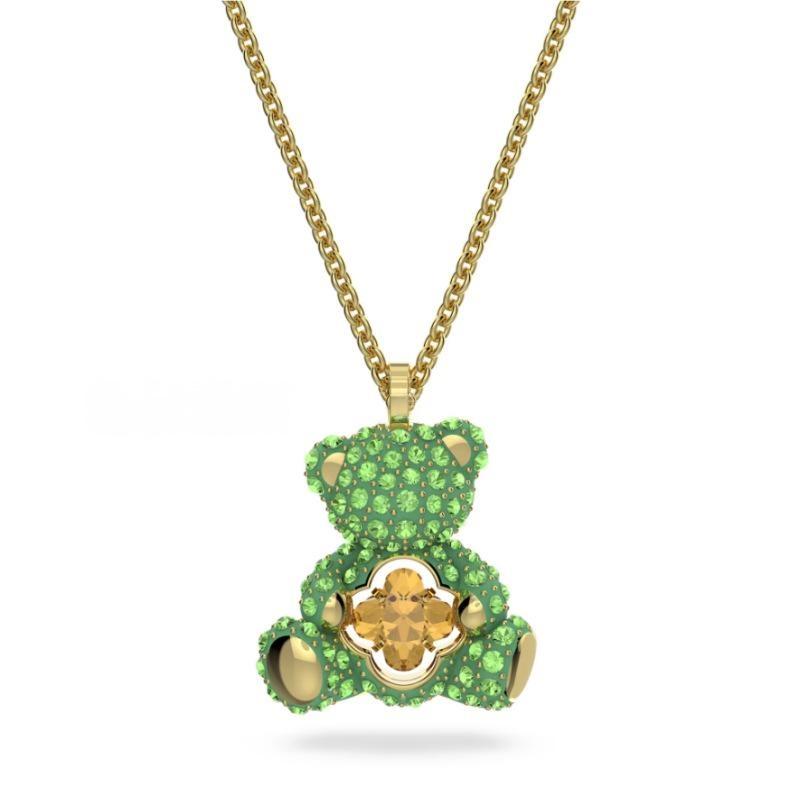 Swarovski Teddy pendant Bear, Pink, Rhodium platedGreen teddy bear pendant with gold accents on a gold chain against a white background
