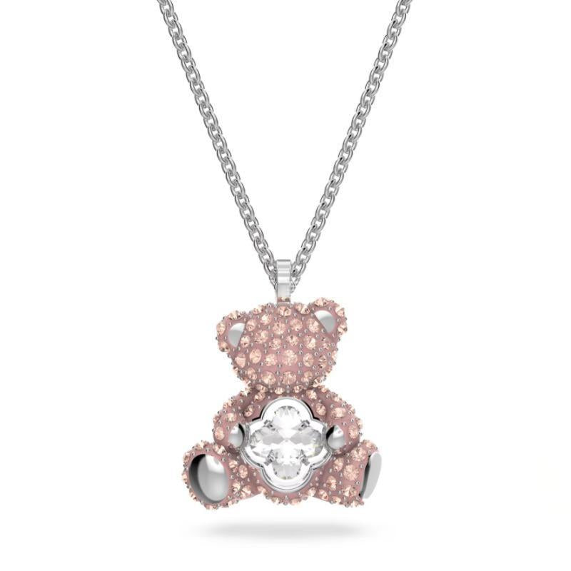 Swarovski Teddy pendant Bear, Pink, Rhodium platedPink teddy bear pendant with a white gemstone on a silver chain against a white background