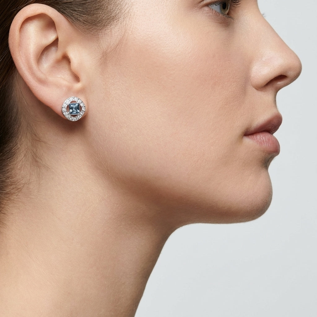 Close-up of a woman wearing a diamond earring on a neutral background