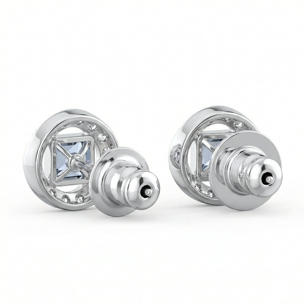 Pair of silver earrings with clear gemstones on a white background
