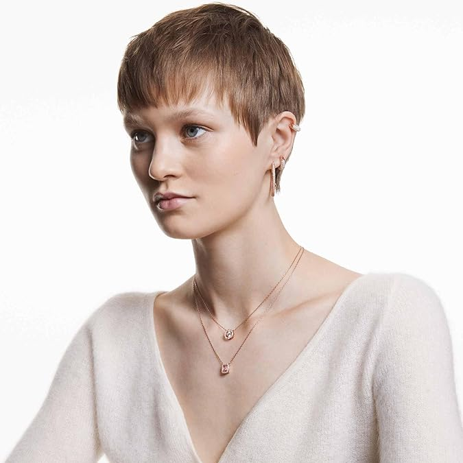 Swarovski Women's Una Crystal Jewelry Collection, Rose Gold Tone FinishWoman wearing a necklace with a plain background