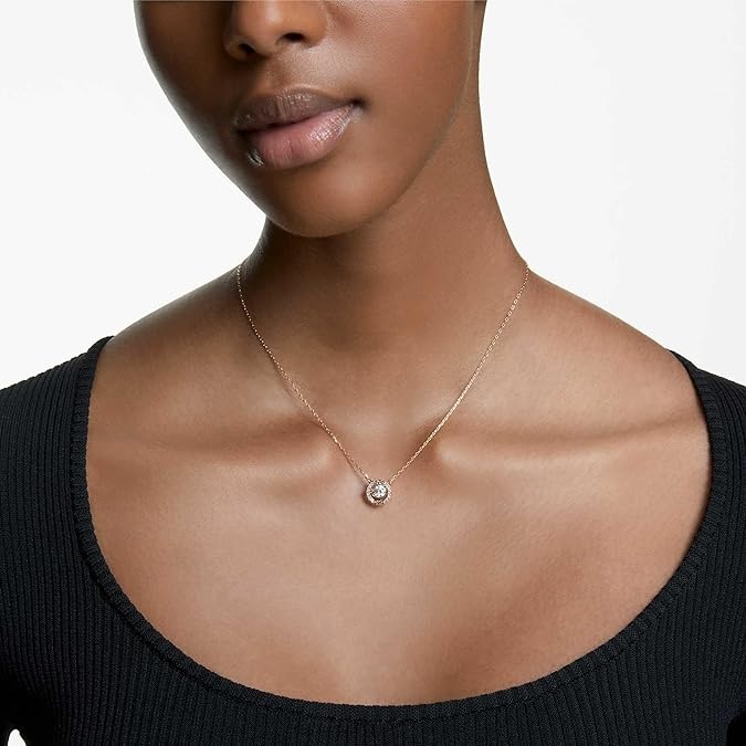 Swarovski Women's Una Crystal Jewelry Collection, Rose Gold Tone FinishNecklace with a pendant worn by a person on a neutral background