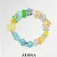Colorful beaded bracelet with butterfly charms on a light gray background, featuring the brand 'Zerra'.