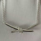 “Close-up of Tiffany Knot pendant design in 18K gold”