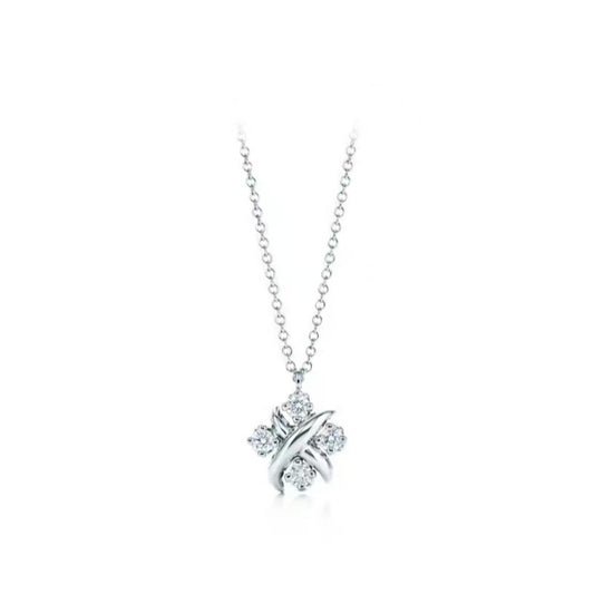 A silver-toned cross pendant necklace set with small clear gemstones, hanging from a delicate silver chain against a solid white background.