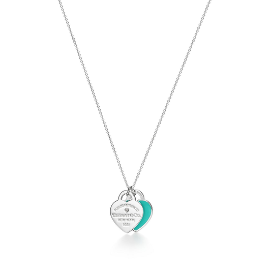 Silver necklace with a heart-shaped pendant on a white background