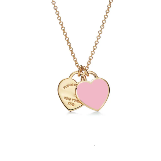 Gold necklace with two heart pendants on a white background