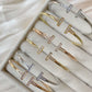 Set of gold and silver 'T' bangles on a soft fabric background