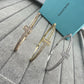 Two gold and silver bangles on a textured surface with a Tiffany & Co. box in the background.