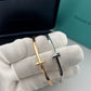 Gold and silver cross-shaped earrings on a white cloth with Tiffany & Co. branding in the background.