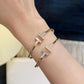 Gold and silver bracelet on a wrist with a blurred background