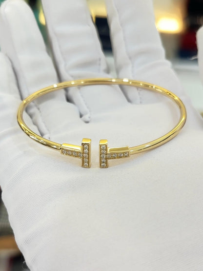 Gold bracelet with diamond accents on a white glove