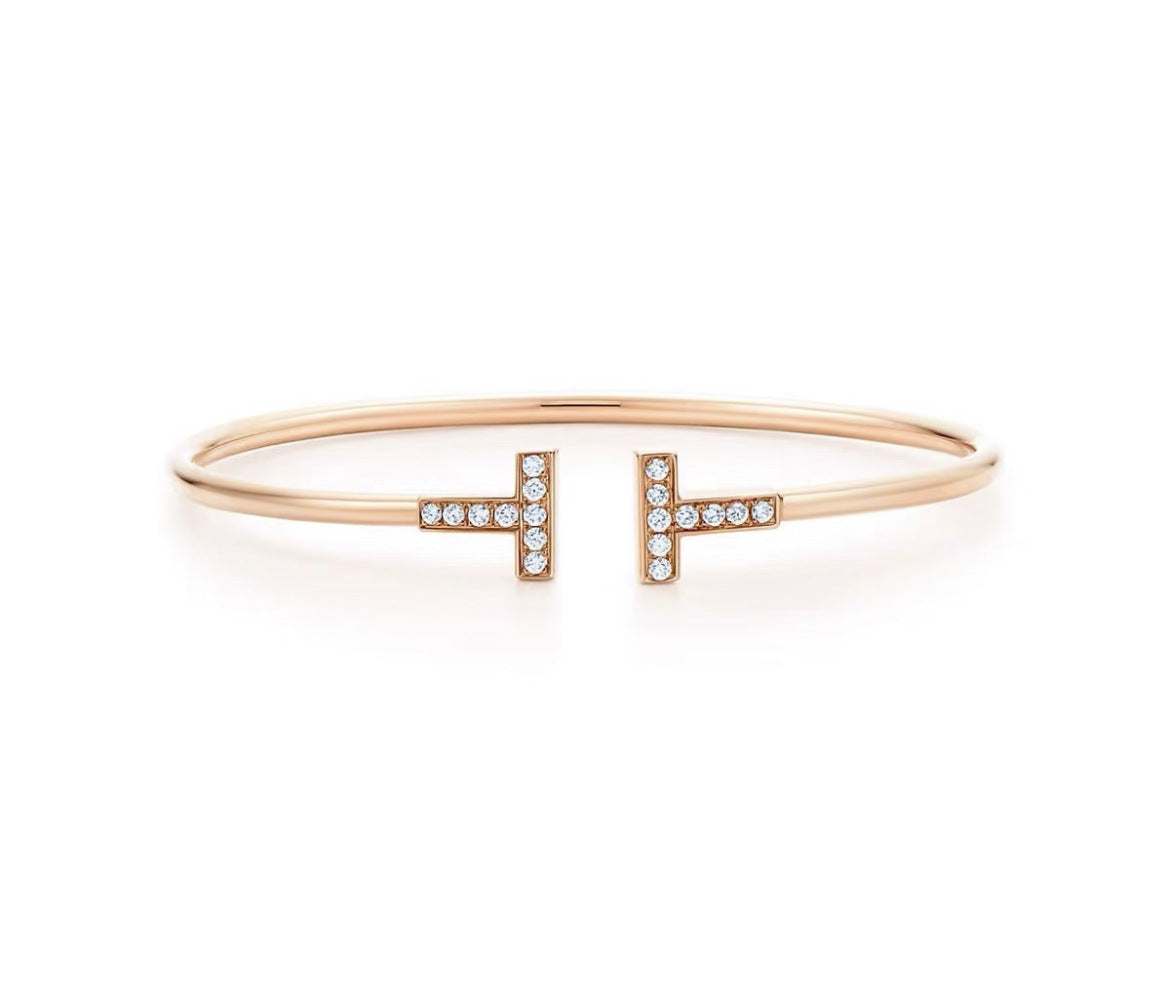 Rose gold bracelet with diamond accents on a white background