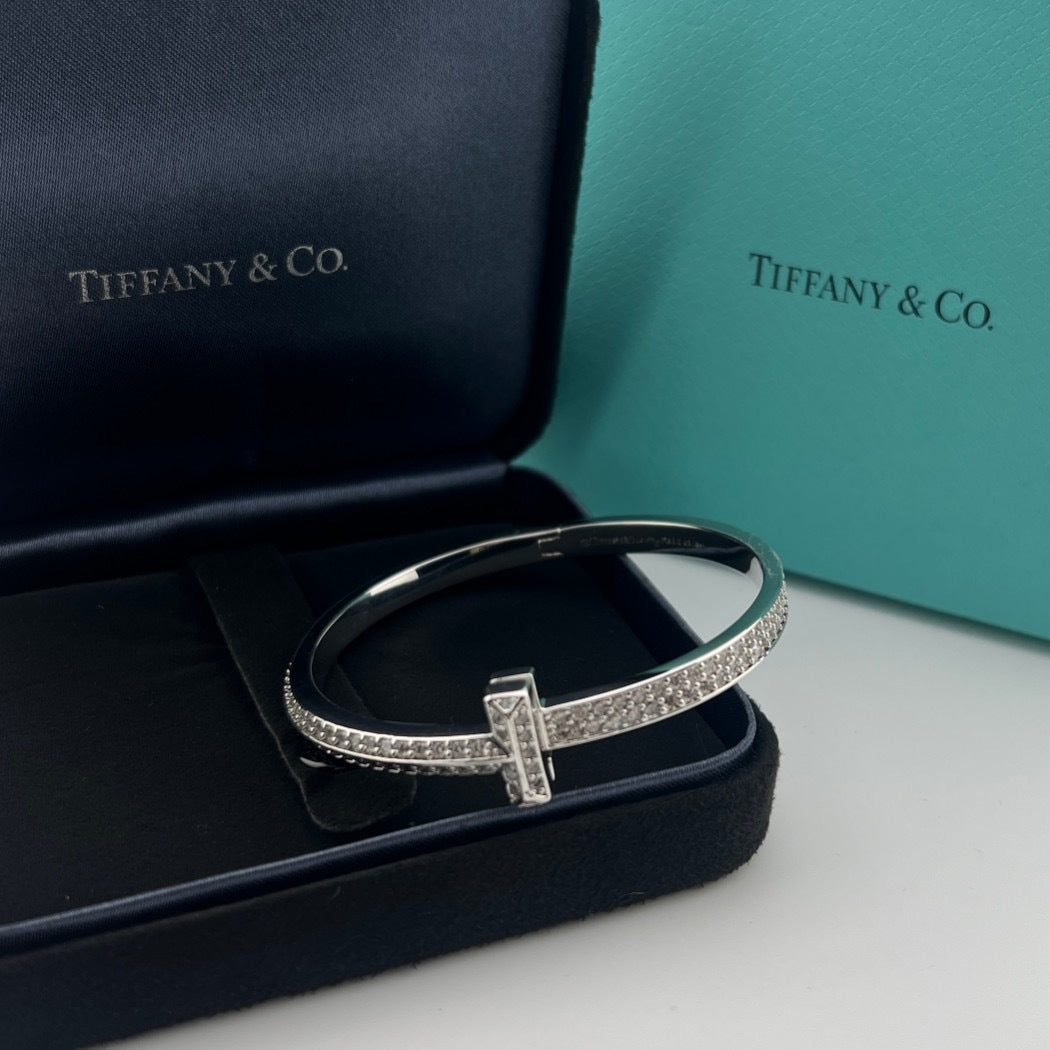 Silver bracelet with diamonds on a black and teal Tiffany & Co. box.
