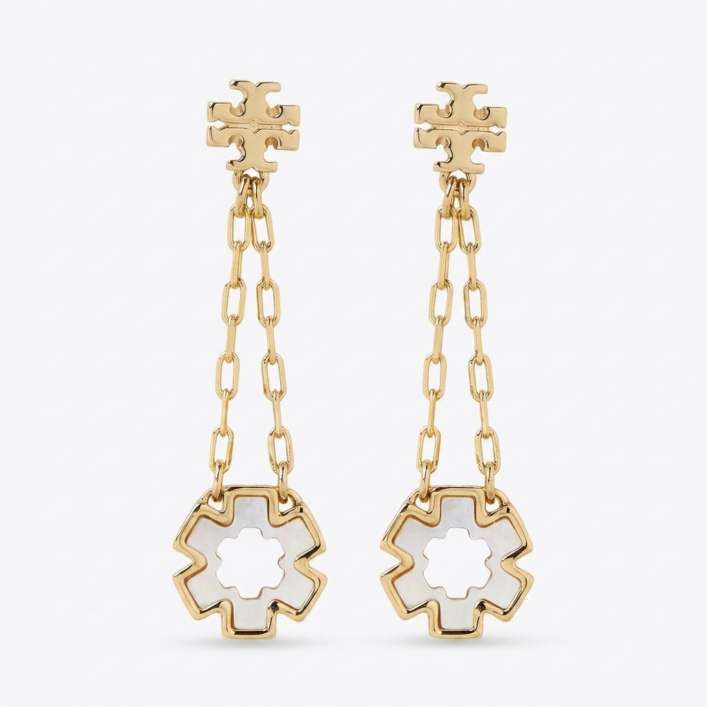 A pair of gold dangle earrings with a geometric flower-shaped stud, a short chain link drop, and a larger matching flower pendant with a white inlay, shown on a light gray background.