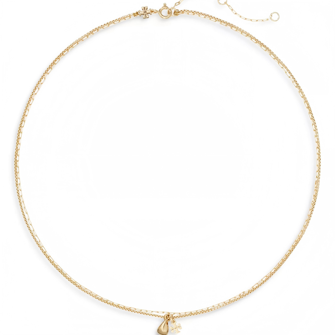 A delicate gold chain necklace with a small teardrop-shaped pendant and a tiny key charm, displayed on a clean white background.