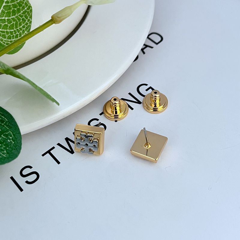 Extreme macro shot focused on the intersection of the two metal tones and the precise, crisp edges of the block letter design.