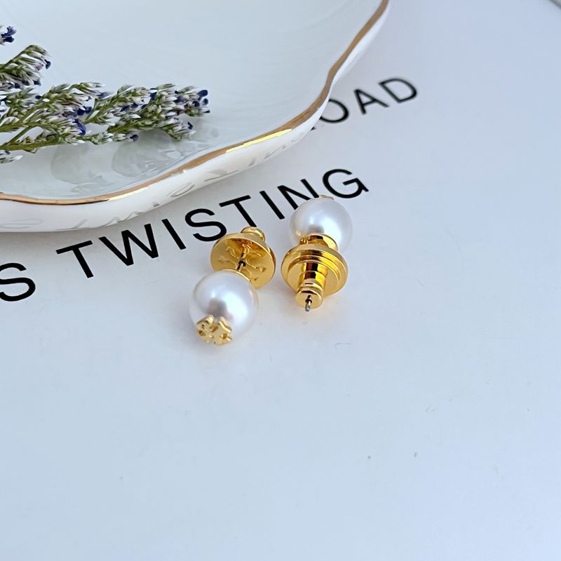 Clean, front-facing shot of a single earring against a soft, neutral background, showcasing the clear link between the Double T logo and the pearl drop.