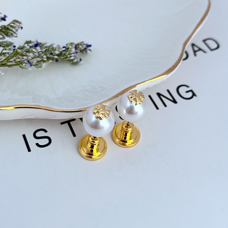 Clean, front-facing shot of a single earring against a soft, neutral background, showcasing the clear link between the Double T logo and the pearl drop.