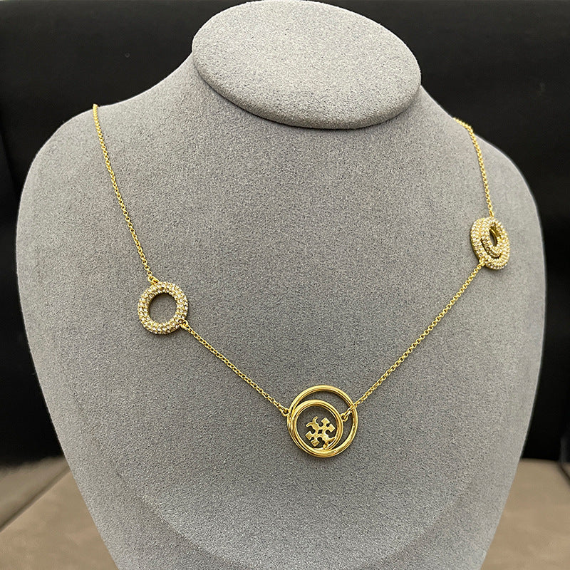 Necklace laid flat on a clean, light background (white or light gray marble), clearly showing the arrangement of the single circle and the three graduated circles along the chain.