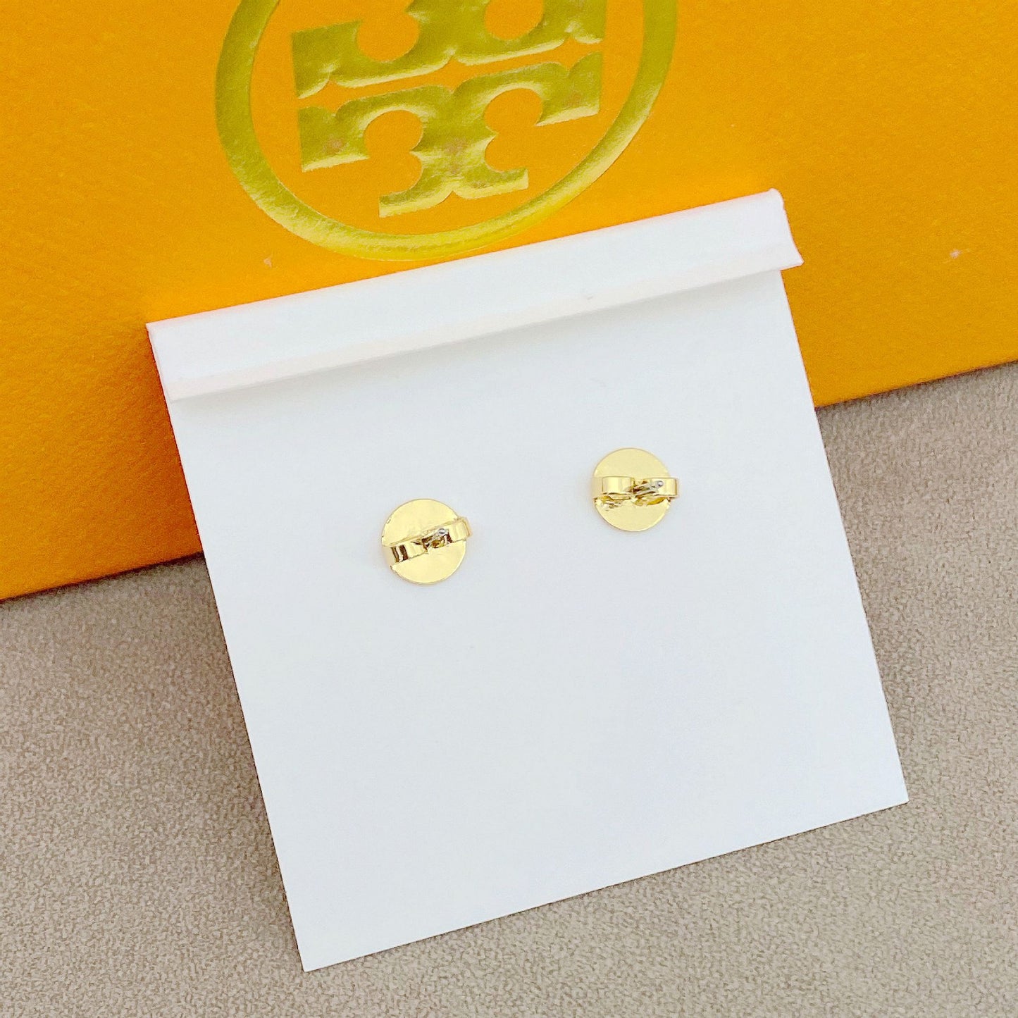 High-definition shot of the pair of earrings laid flat on pure white background, arranged symmetrically.