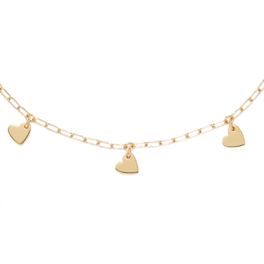 A delicate gold chain necklace featuring three small, flat heart-shaped charms spaced along the chain, set against a plain white background.