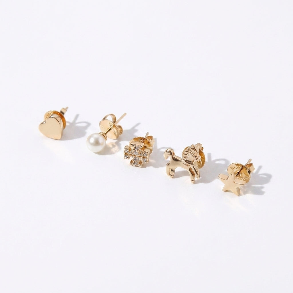 A set of five gold-toned stud earrings arranged diagonally on a white background, including a heart, pearl, flower, horse, and star designs.
