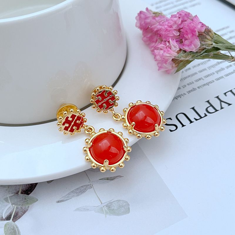  Clean, vertical shot of a single earring against a light grey or white background, highlighting the sharp contrast between the 18k gold plating and the black enamel.