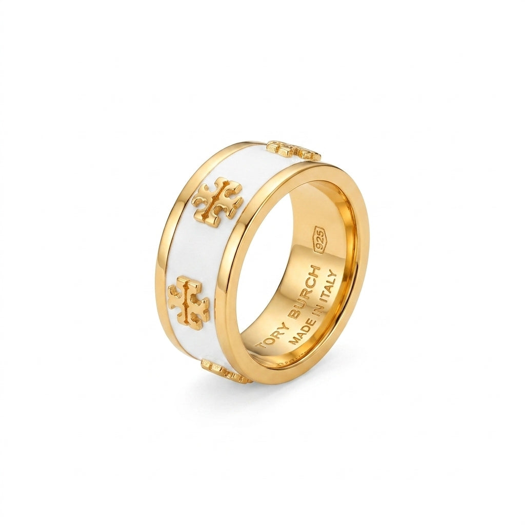A gold-plated ring with a white enamel inlay and gold-tone cross motifs on the outer band, shown on a clean white background. The inner band is engraved with 'OR P.