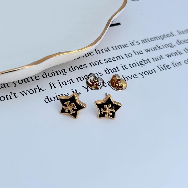 Clean shot of a single earring against a dark blue or midnight-inspired background, making the star charm and its sparkle stand out like a star in the night sky.