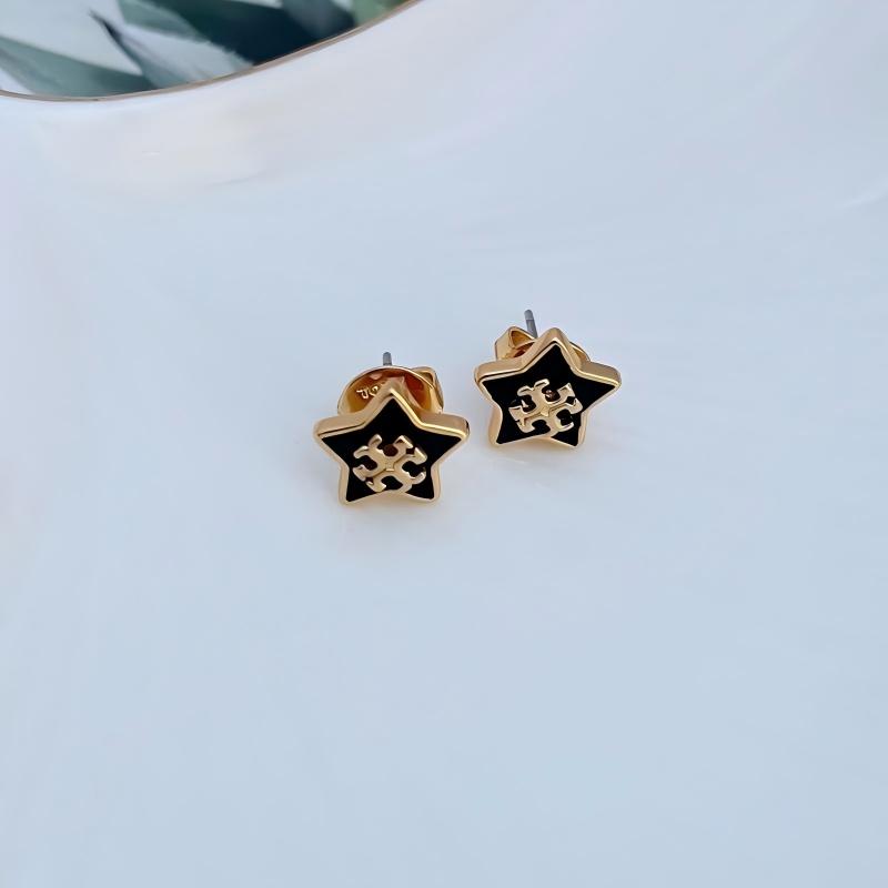 Clean shot of a single earring against a dark blue or midnight-inspired background, making the star charm and its sparkle stand out like a star in the night sky.