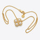 A gold chain necklace featuring a four-petal flower pendant with four white pearls and a small central gold heart, displayed on a light gray background.