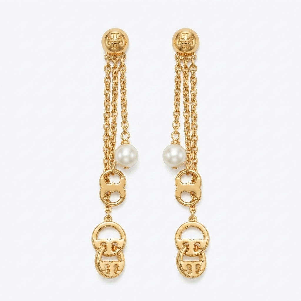 A pair of gold dangle earrings with triple chain drops, white pearl beads, and interlocking gold logo charms at the bottom, shown on a light gray background.