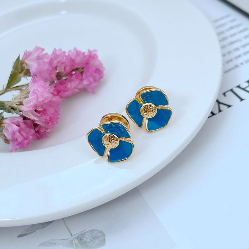 Clean, crisp shot of a single stud against a soft, neutral background (like light grey or cream), highlighting the contrast between the white enamel and the gold-tone metal.