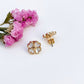 Gold floral earrings with pink flowers on a white background