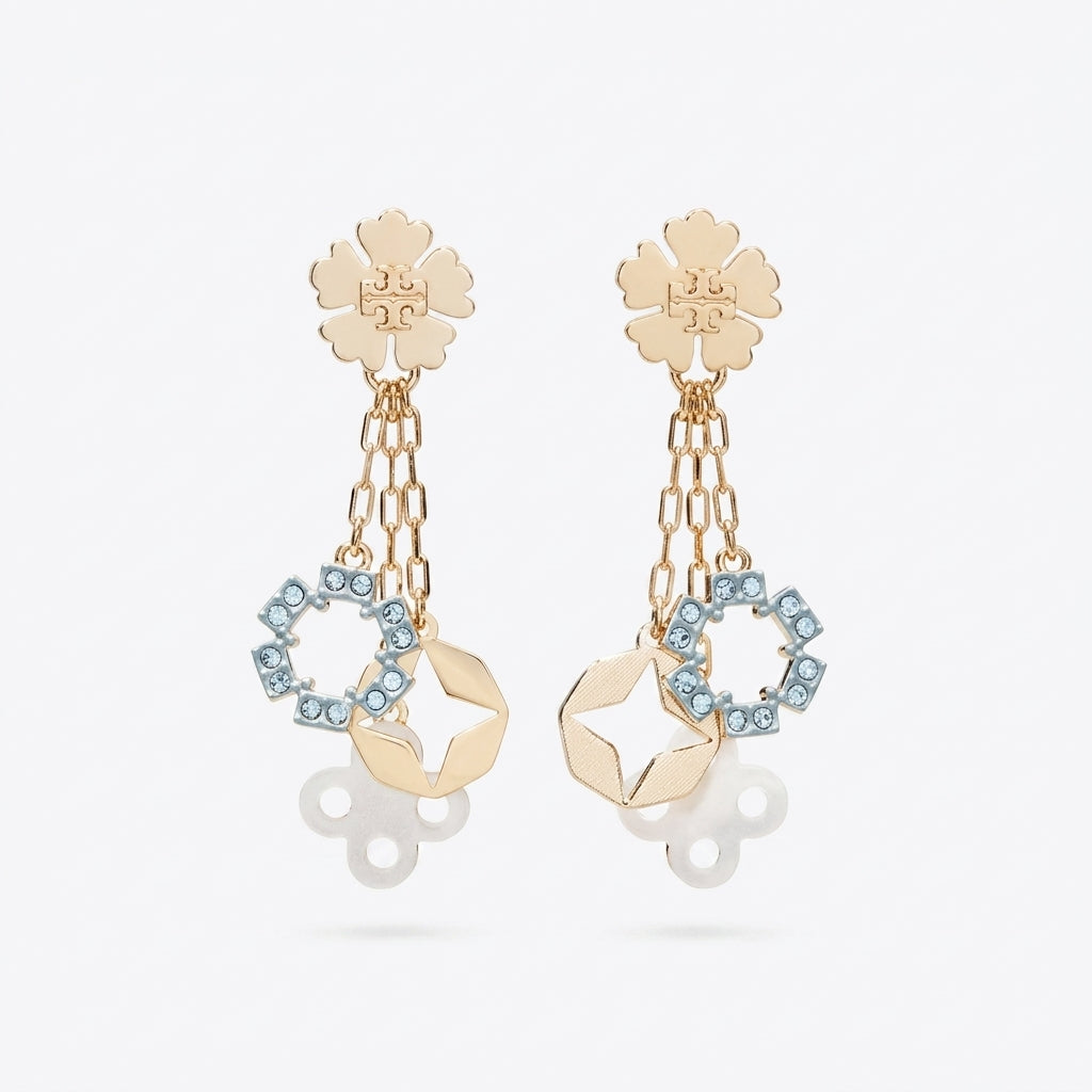 A pair of gold-tone dangle earrings featuring a flower-shaped stud, hanging chain links, a geometric gold charm, and a circular ring set with light blue rhinestones, shown against a light gray background.