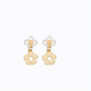 A pair of gold-tone flower-shaped dangle earrings with white enamel clover studs, shown on a plain white background.