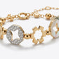 A gold-toned bracelet featuring geometric star-shaped charms, a pavé-set clear stone octagonal charm, and an iridescent shell inlay, photographed on a clean light gray background.