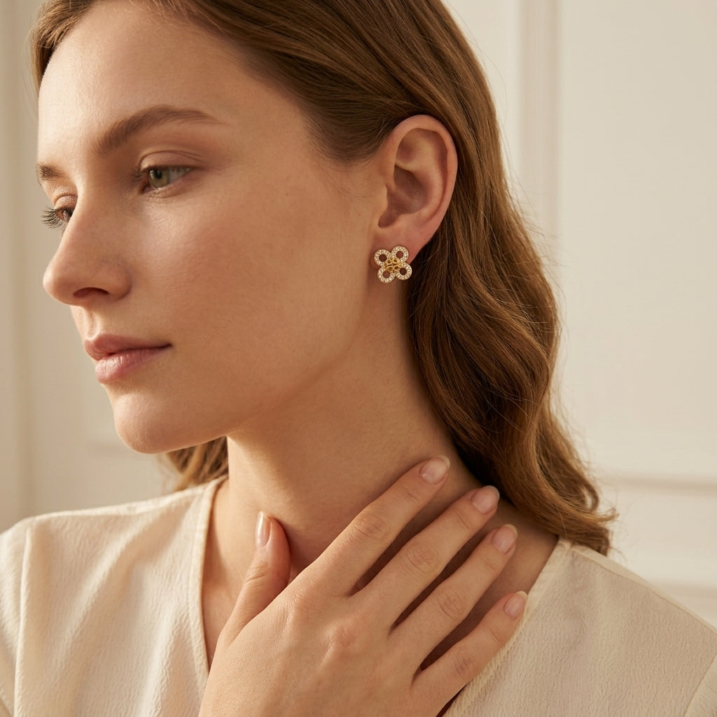Close-up of a woman wearing gold earrings with a neutral background