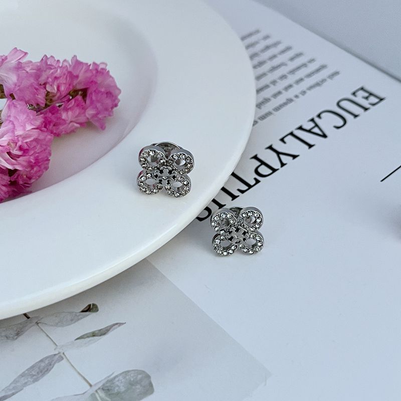 Extreme close-up of one stud, focusing on the pave crystal petals and the metal outlines of the flower.