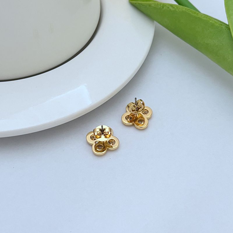 Clean, front-facing macro shot of a single earring against a soft, blurred botanical background or neutral tone, showcasing the intricate cluster of flowers and leaves.