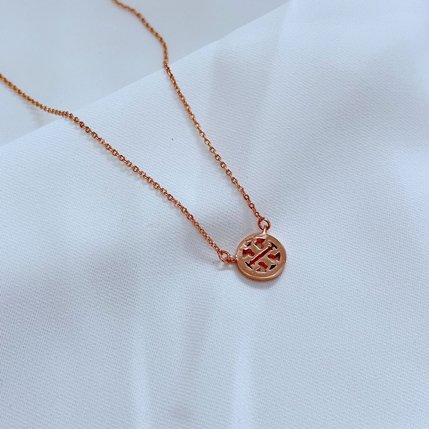 Extreme close-up of the circle pendant, focusing on the pavé crystal setting, metal edges, and overall craftsmanship.