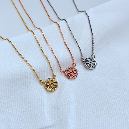 The necklace displayed on a clean, dark background (charcoal or black velvet) to make the gold circle and crystal sparkle stand out dramatically.