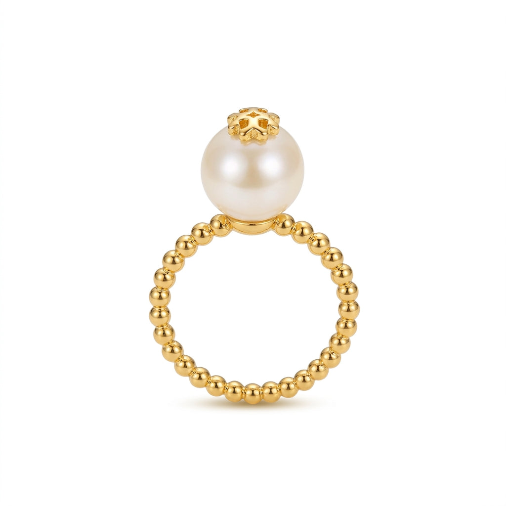 A gold beaded ring featuring a large white pearl suspended at the top, set against a clean white background.