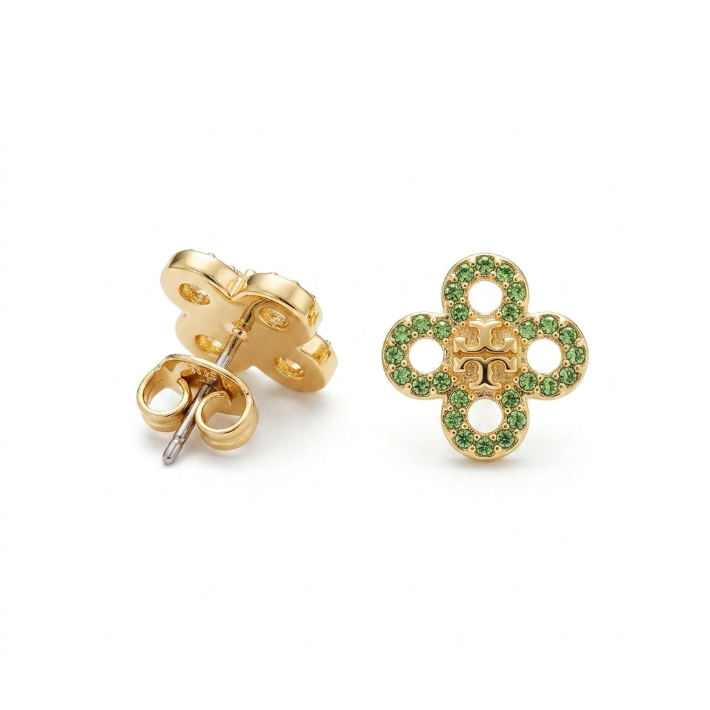 A pair of gold flower-shaped stud earrings, one showing the back with a butterfly clutch and the other showing the front decorated with small green stones around the perimeter.