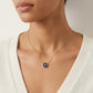 Close-up from lips to chest, cropped above the mouth. Model in a white top, wearing a single necklace.