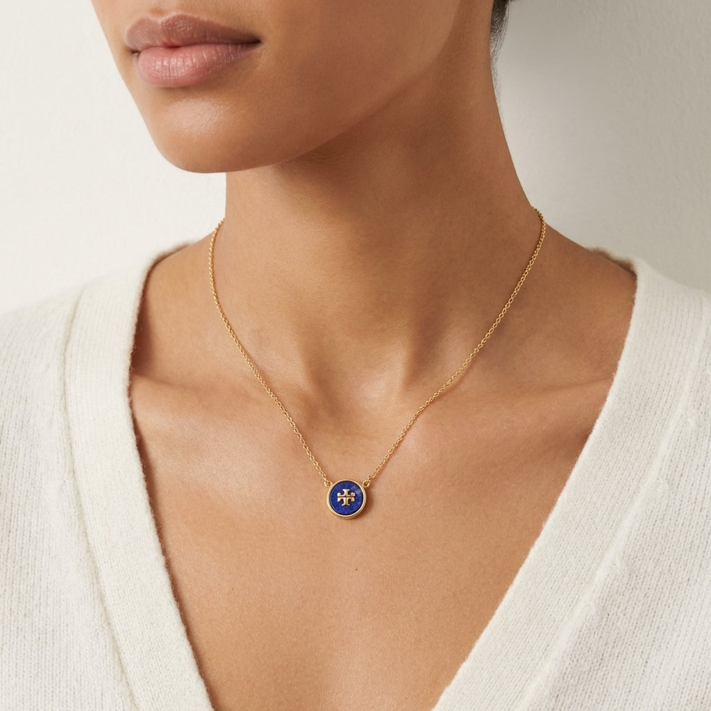Close-up from lips to chest, cropped above the mouth. Model in a white top, wearing a single necklace.