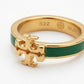 A gold ring with a green enamel inlay and a prominent gold monogram logo on the front, shown on a clean white background. The inside of the band is engraved with 'S22' and the Burch logo.