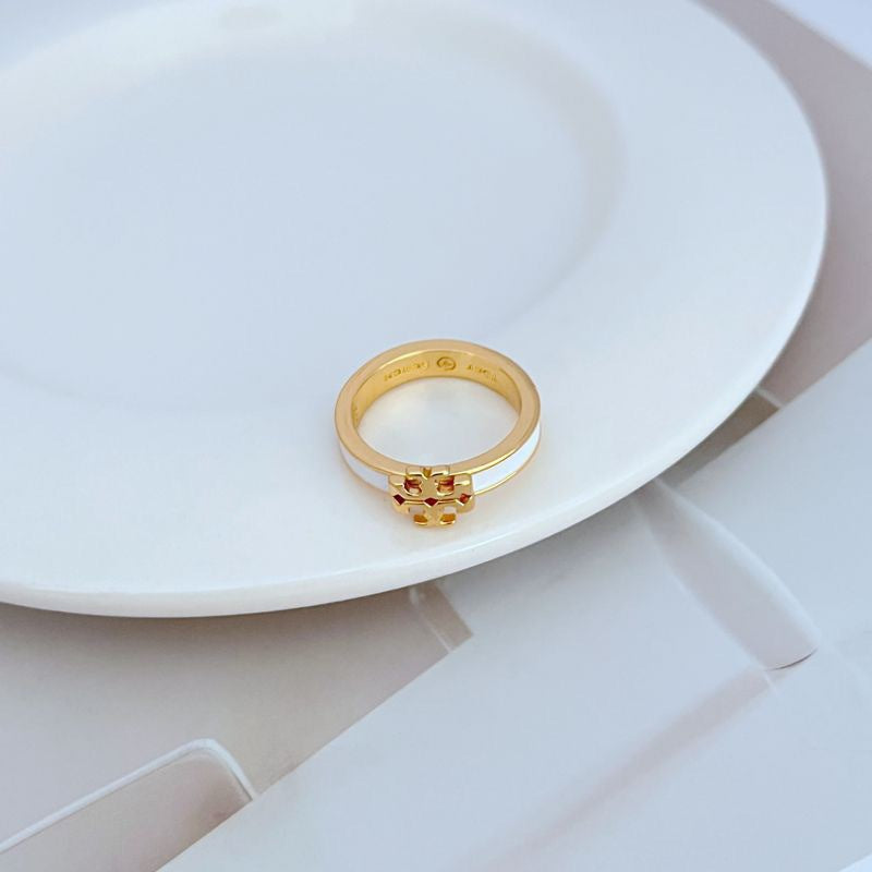  Clean, bright shot of the ring on a neutral background, making the colored enamel and gold logo the clear focal point.